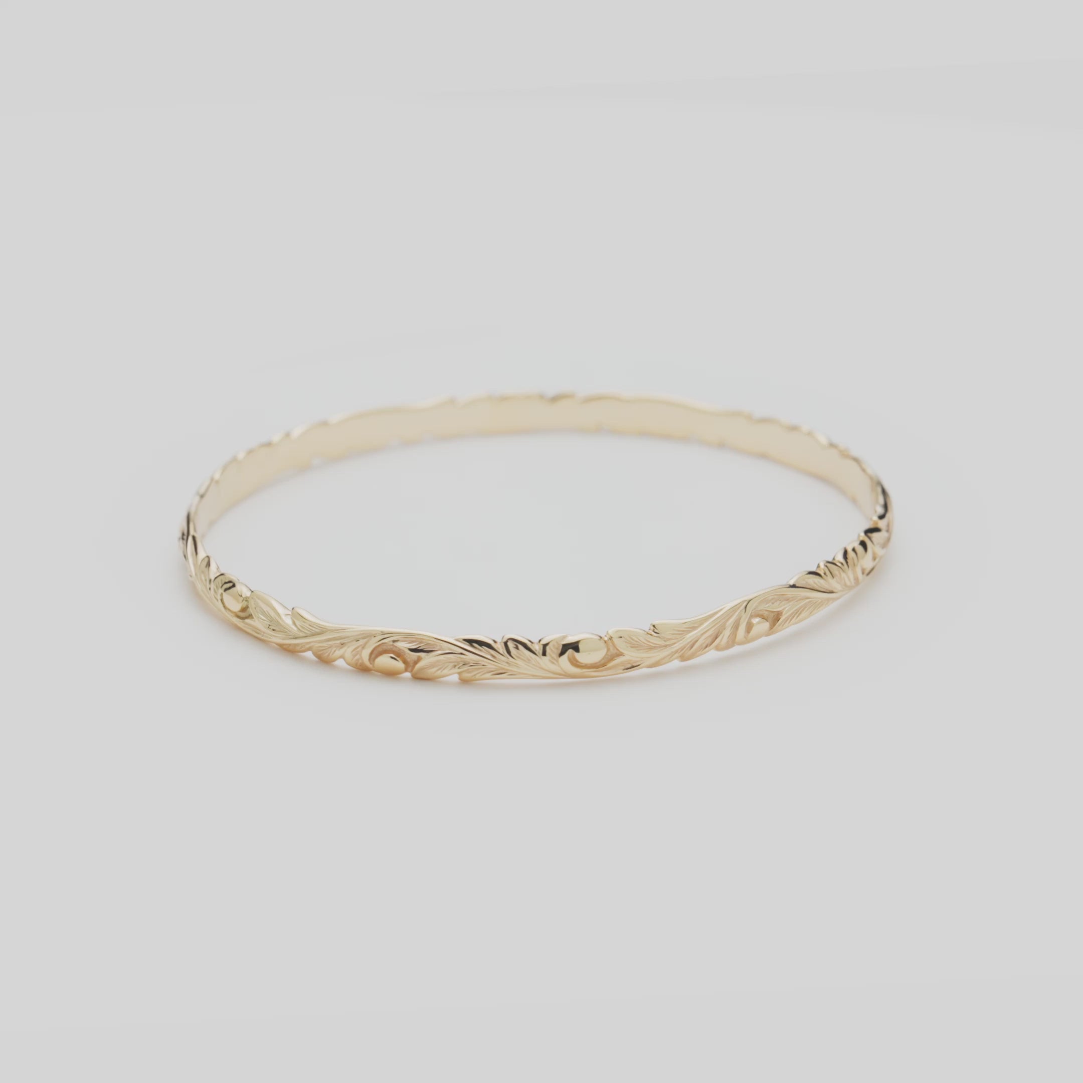 Video of the 4.5mm Hawaiian Heirloom Old English Scroll Bracelet in Gold turning on a white background