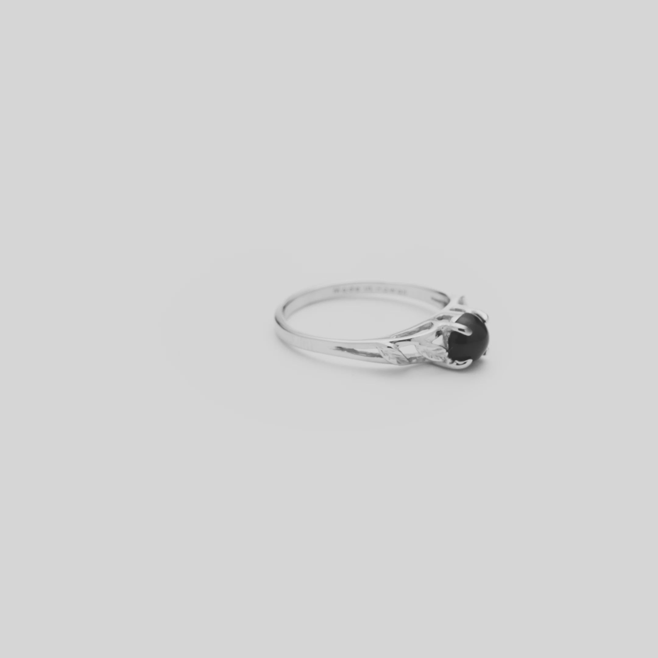 Video of the 5mm Maile Black Coral Ring in White Gold turning on a white background