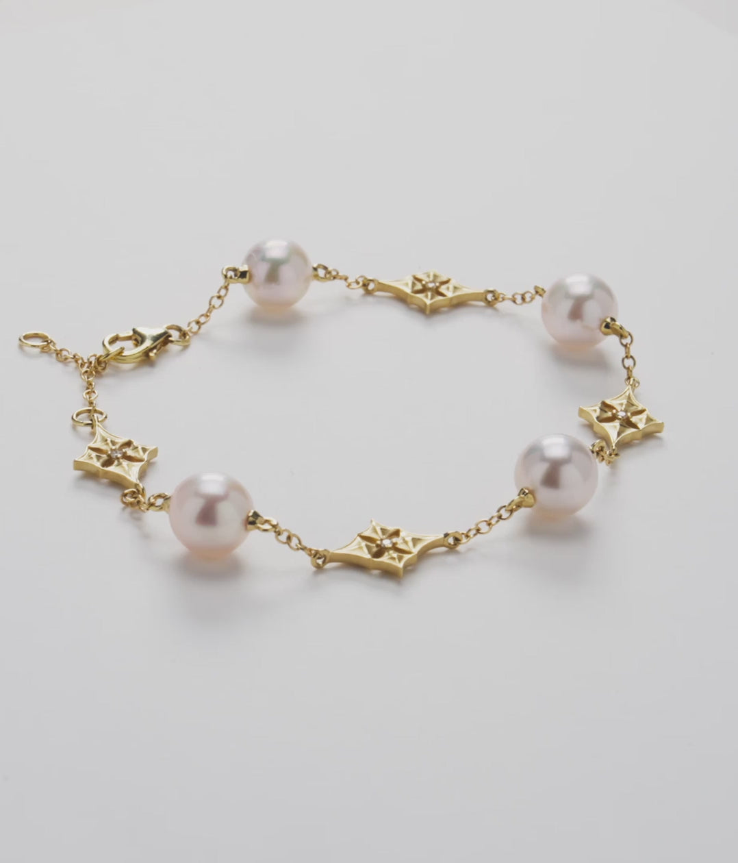 7-8" Hawaiian Quilted Star 8mm Akoya White Pearl Bracelet in Gold with Diamonds on a white turntable