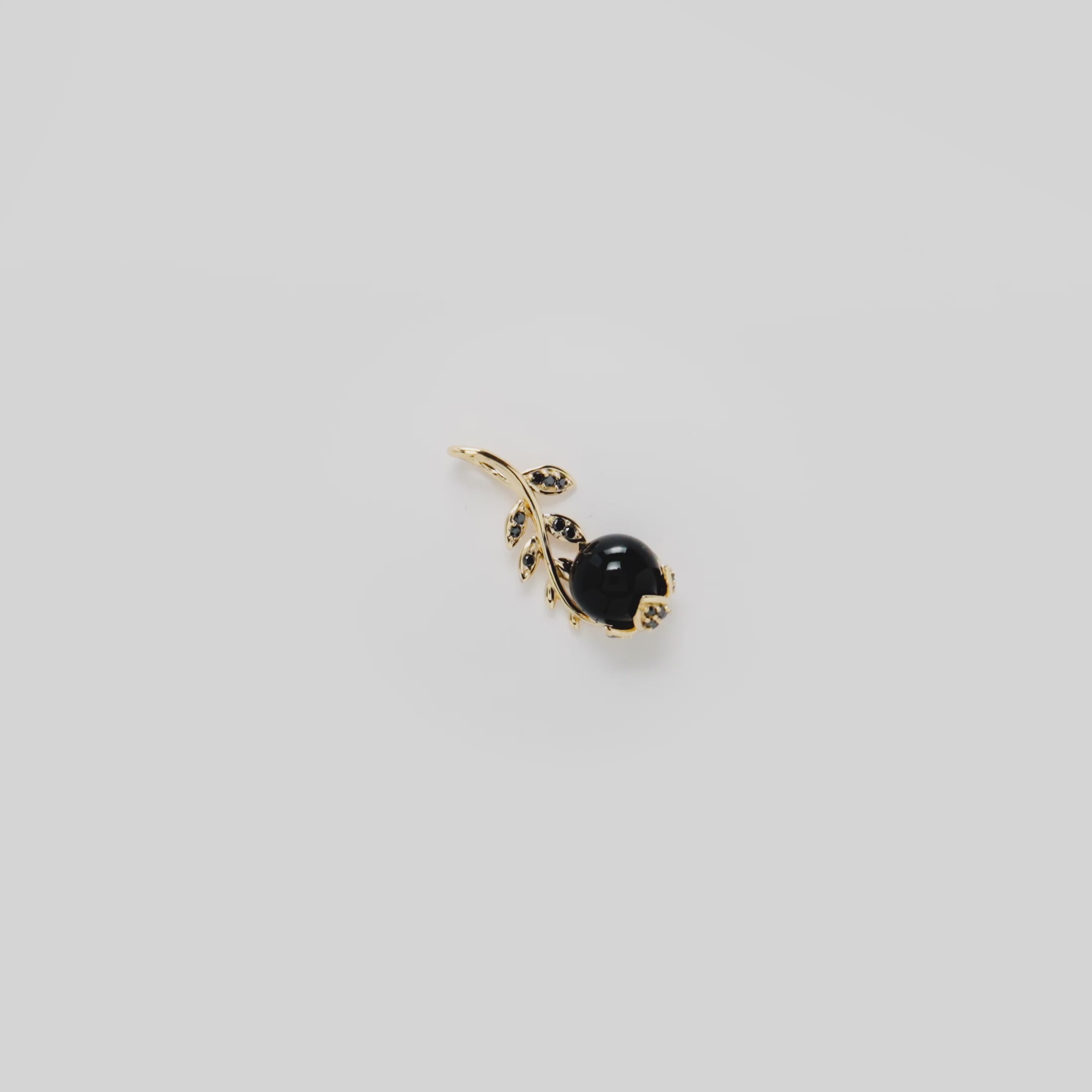 Video showcasing the Night Blossom Black Coral Pendant in 14k Yellow Gold with Black Diamonds on a turn table