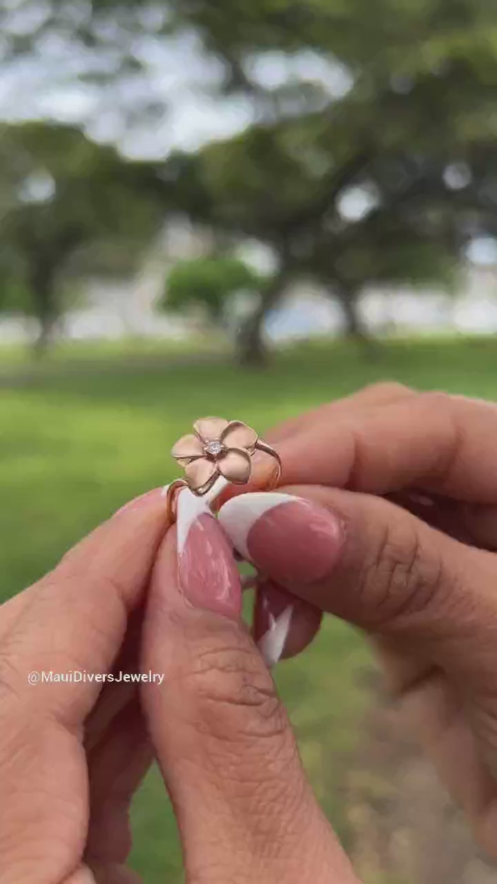 Video of a woman's hand wearing a Plumeria Ring in Rose Gold with Diamond and an Aloha Ring in Rose Gold- Maui Divers Jewelry
