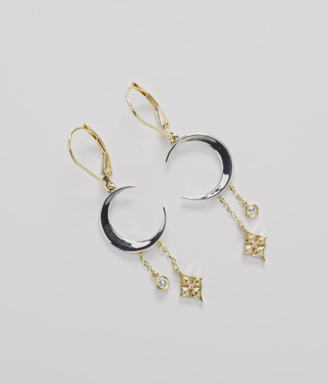 35mm Hawaiian Quilted Star and Moon Leverback Earrings in Two Tone Gold with Diamonds on a white turntable