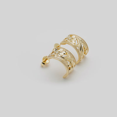Video showcasing the Hawaiian Heirloom Plumeria Scroll Half-Hoop Earrings in 14k Yellow Gold on a turn table