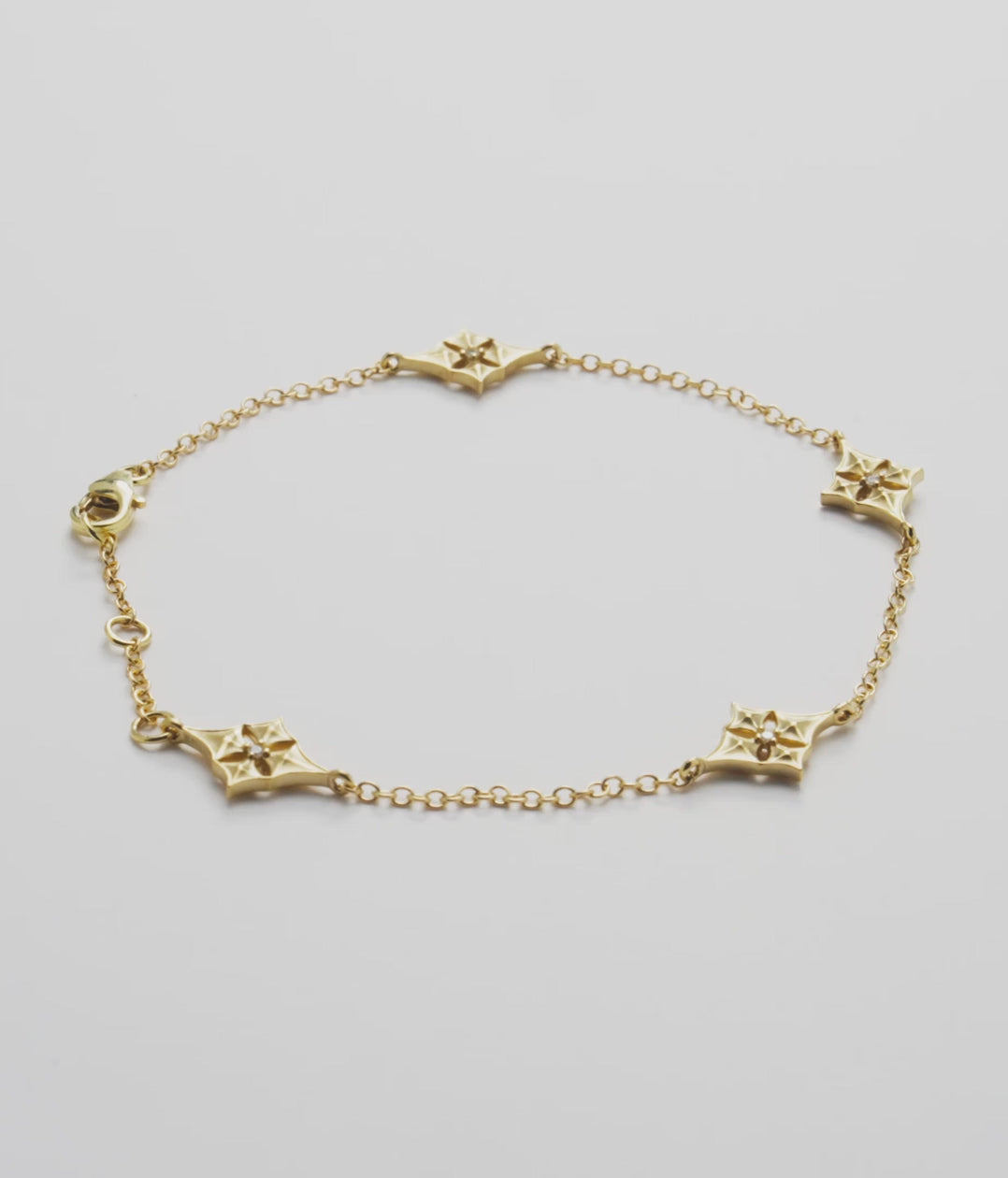Video showcasing the Hawaiian Quilted Star Bracelet in 14k. Yellow Gold with Diamonds on a white turntable