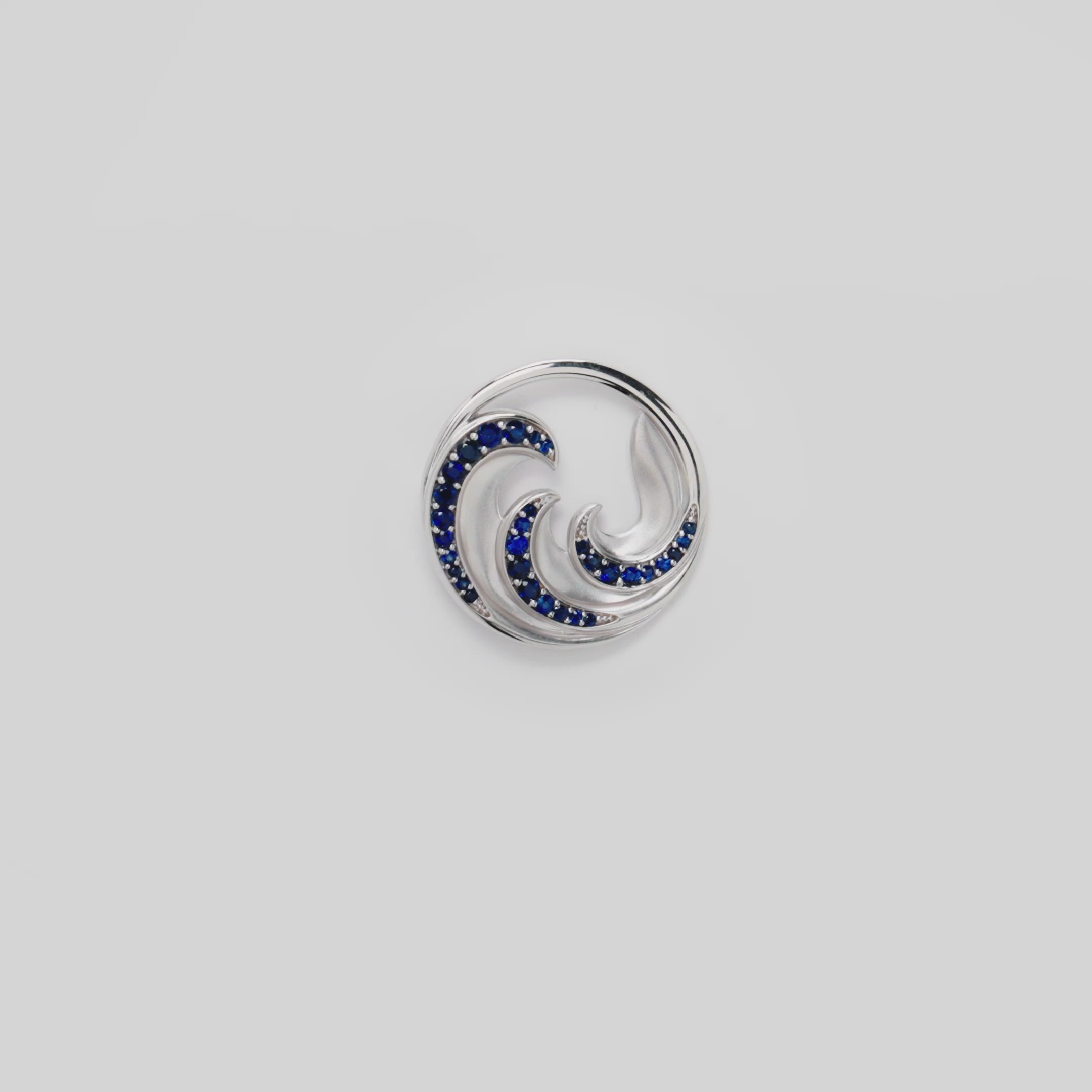 Video of the 24mm Nalu Pendant in White Gold with Blue Sapphires on a turn table