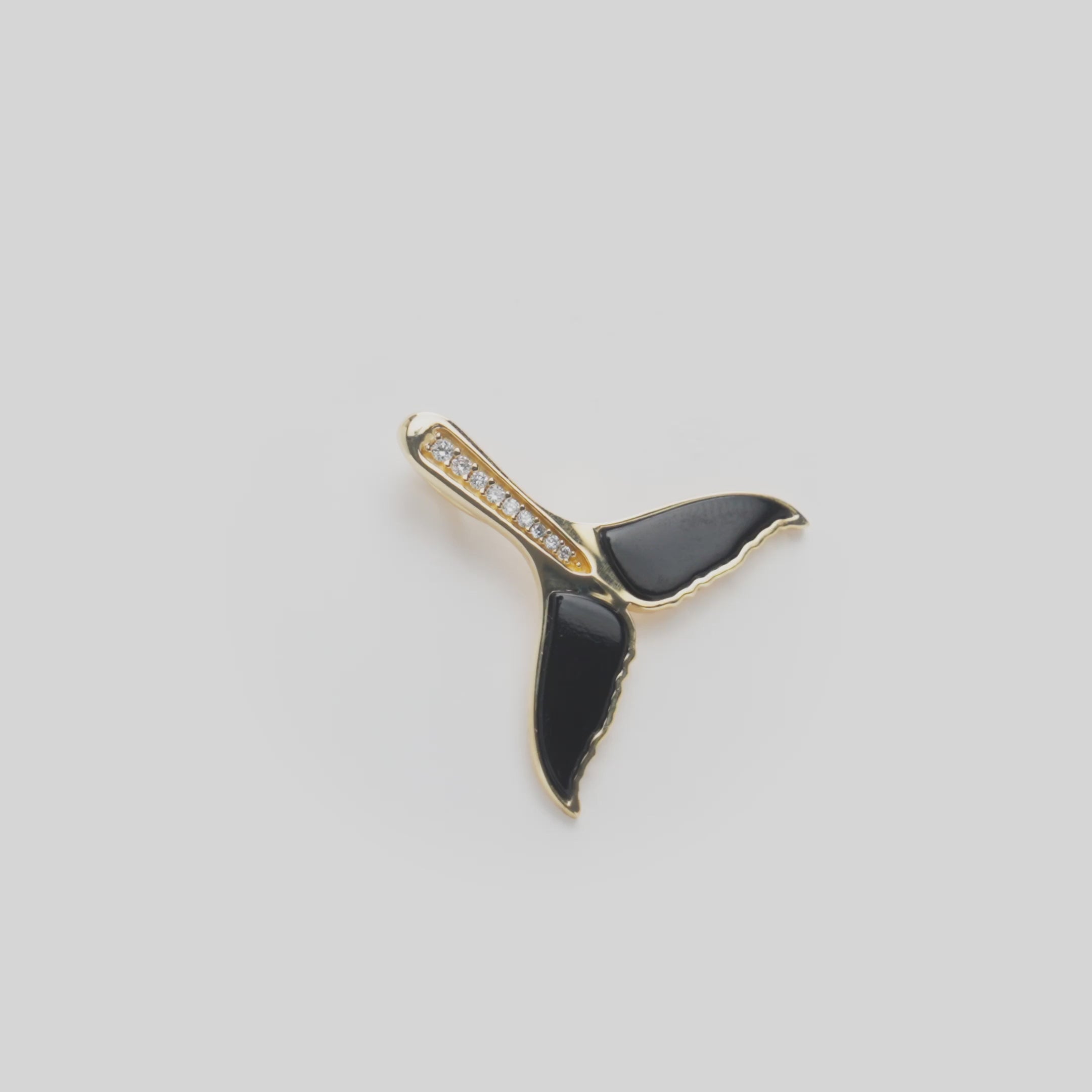 Close up video of Sealife Whale Tail Black Coral Pendant in Gold with Diamonds on white turn table
