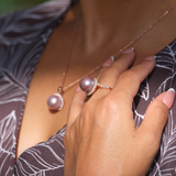 A woman's hand with a Ultra Violet Freshwater Pearl Ring with Diamonds in Rose Gold (14-15mm) on it laying of her chest-Maui Divers Jewelry