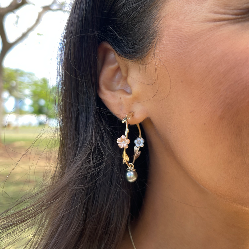 A woman's ear with Pearls in Bloom Plumeria Tahitian Black Pearl Earrings in Tri Color Gold with Diamonds - 33mm - Maui Divers Jewlery