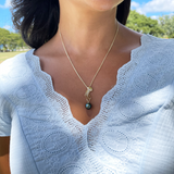 A woman wearing an Ocean Dance Jellyfish Tahitian Black Pearl Pendant in Gold with Diamonds - 9-10mm - Maui Divers Jewelry