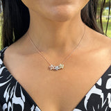 A woman wearing three different sizes of a Plumeria Pendant in White Gold with Diamond - 9mm-Maui Divers Jewelry