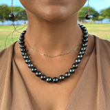 A woman's chest  with a Tahitian Black Pearl Strand with Gold Clasp - 10-11mm - Maui Divers Jewelry