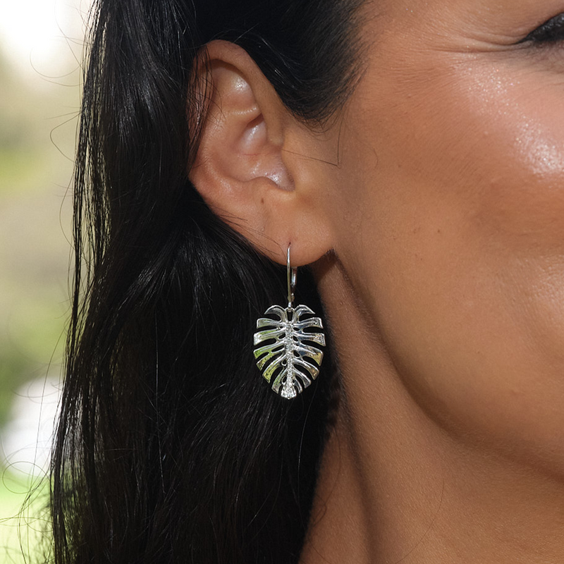 A woman's ear with Monstera Earrings in White Gold with Diamonds - 23mm - Maui Divers Jewelry