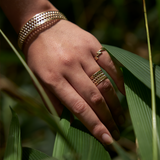 A womanʻs hand with a Kamohoaliʻi ʻIwa Bird Feather Ring in Gold - 11mm - Maui Divers Jewelry