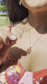 Video of a woman holding a Honu Ohana Pendant in Gold - 19mm - Maui Divers Jewelry
