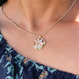 A woman wearing a Hawaiian Gardens Hibiscus Pendant in Tri Color Gold with Diamonds - 20mm - Maui Divers Jewelry