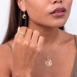 A woman wearing a Nalu Ring in Gold, a necklace and earrings - Maui Divers Jewelry