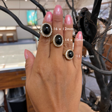 A woman's hand wearing three sizes of the Princess Ka‘iulani Black Coral Ring in Gold with Diamonds-Maui Divers Jewelry