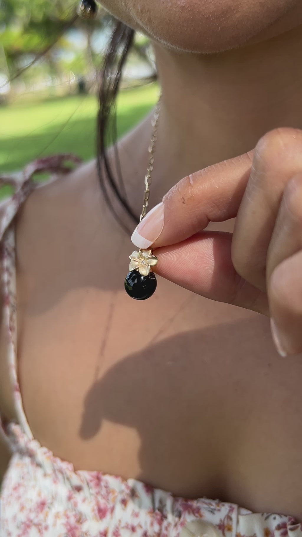 Video of a woman wearing a Plumeria Black Coral Pendant in Gold with Diamonds - Maui Divers Jewelry